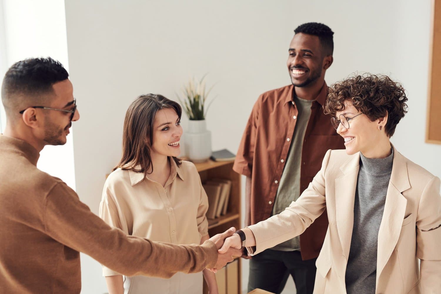 Four professionals greeting each other with a handshake.